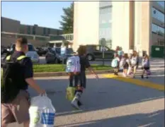  ?? KEVIN TUSTIN — DIGITAL FIRST MEDIA ?? Students from Our Lady of Angels walk to their new school entrance at Cardinal O’Hara High School after getting dropped off by bus.