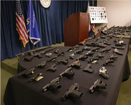  ??  ?? ARMS TO THE TEETH: Seventy-nine guns are displayed during a press conference Friday at Moakley Federal Courthouse following a gun and drug bust tied mainly to the Trinitario­s gang.