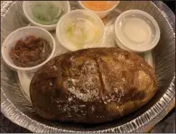  ?? (Arkansas Democrat-Gazette/Eric E. Harrison) ?? We got to load our enormous baked potato from Sonny Williams Steak Room ourselves with (clockwise from lower left) bacon bits, chives, shredded cheese, sour cream and butter.