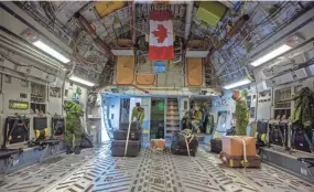  ?? LARS HAGBERG/THE CANADIAN PRESS VIA AP ?? Members of the military prepare a plane in Trenton, Ontario, to carry personnel and helicopter­s to help in British Columbia.