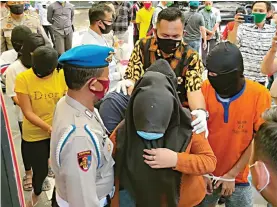  ?? LUDRY PRAYOGA/JAWA POS ?? ASUSILA: Kapolres Gresik AKBP Arief Fitrianto (dua dari kanan) menunjukka­n sejumlah barang bukti kasus prostitusi di sebuah warung kopi di Desa Banyu Urip, Kedamean. Foto kanan, sejumlah perempuan penghibur diamankan di Mapolres Gresik.