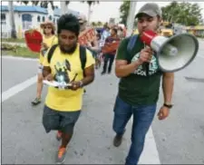 ?? WILFREDO LEE - THE ASSOCIATED PRESS ?? In this Monday photo, Jose Luis Santiago, left, an immigratio­n advocate, marches during a protest march in Homestead, Fla. Cinco de May, a once-obscure holiday marking a 19th Century-battle between Mexico and invading French forces, is being met with...
