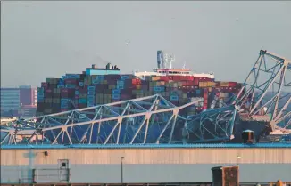  ?? ROBERTO SCHMIDT / AGENCE FRANCE-PRESSE ?? The steel frame of the Francis Scott Key Bridge sits on top of a container ship after it hit the structure in Baltimore, Maryland, on Tuesday.