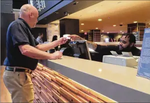  ?? AP ?? A customer receives a betting ticket at the Tropicana casino in Atlantic City Thursday. American gamblers have wagered over $125 billion on sports with legal betting outlets in the four years since the U.S. Supreme Court cleared the way for all 50 states to offer legal sports betting.