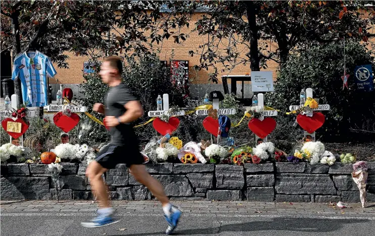  ??  ?? A man runs along the West Side Highway bike path yesterday, past memorials to the victims of Wednesday’s truck attack, which killed eight people. The carnage has seen security stepped up along the route of the New York City Marathon.