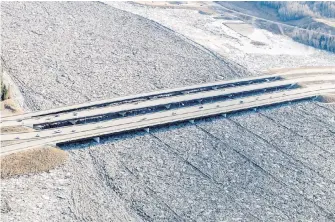  ??  ?? Striations seen in an ice jam are caused by the piers of three bridges that cross the Athabasca River in Fort McMurray, Alta. A 25-kilometre-long ice jam caused major flooding and forced more than 12,000 people from their homes early in the week.