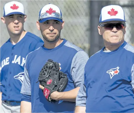  ?? FRANK GUNN/THE CANADIAN PRESS ?? Toronto pitchers Aaron Sanchez, from left, Marco Estrada and manager John Gibbons keep an eye on the action at Blue Jays spring training in Dunedin, Fla.