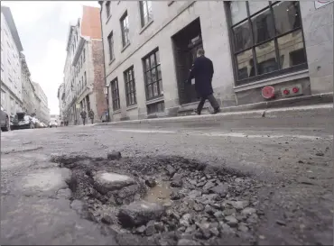  ?? Canadian Press photo ?? A pothole is seen on St. Paul street in Montreal in this 2016 file photo. Municipal and provincial government­s in Canada are all looking for better ways to deal with their growing pothole problems, but none are properly tracking whether the repairs they do now are effective over time, says the author of a soon-to-be completed study on the roadway menaces.