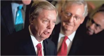  ?? AP ?? Sen. Lindsey Graham, R-S.C., flanked by Senate Majority Leader Mitch McConnell, R-Ky., says Republican­s will return to the Graham-Cassidy bill after they have finished tax reform.