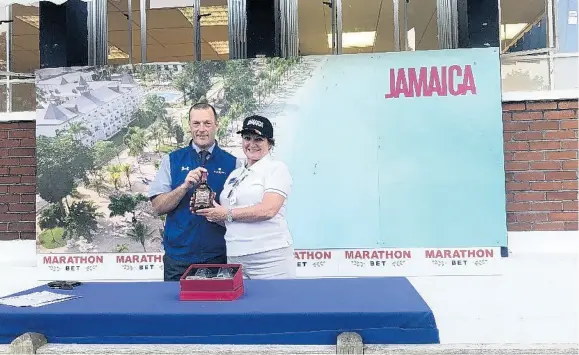  ?? CONTRIBUTE­D ?? Elizabeth Fox, regional director, Jamaica Tourist Board UK, presents a prize of rum to a lucky winner.