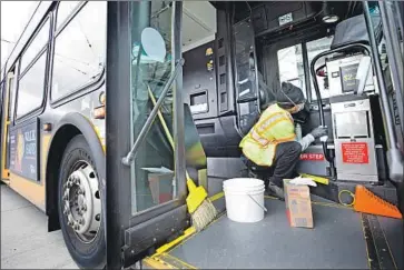  ?? Karen Ducey Getty Images ?? TYLER GOODWIN cleans a bus from the King County f leet in Seattle. Even with the rise in coronaviru­s deaths in the U.S. — all in Washington state — health officials say there’s still time to slow the spread of virus.