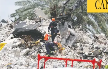  ?? JOE RAEDLE / GETTY IMAGES ?? Search personnel and sniffer dogs continue working in the rubble pile of the 12-storey Champlain
Towers South condo earlier this week in Surfside, Fla. Over one hundred people are still missing.