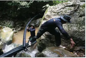  ?? AP/SAKCHAI LALIT ?? Thai soldiers on Saturday drag a pipe intended to prevent water from entering the cave in Mae Sai where 12 boys and their soccer coach are trapped.