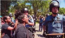  ?? ASSOCIATED PRESS FILE PHOTOS ?? Wintana Melekin speaks to a line of St. Paul police as police and protesters face off on Summit Avenue, a block from the governor’s residence, in St. Paul, Minn., Tuesday.