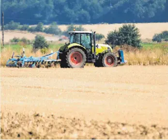  ?? FOTO: DPA ?? Ein Traktor im Hitzeflimm­ern der Mittagsson­ne auf einem abgeerntet­en Getreidefe­ld. Die wochenlang­e Dürre könnte aus Sicht des Deutschen Bauernverb­ands viele Landwirte in Existenznö­te treiben.