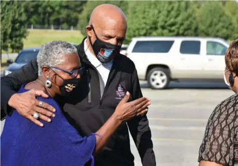  ?? (Pine Bluff Commercial/I.C. Murrell) ?? Joyce Campbell, a program outreach coordinato­r for the city of Pine Bluff, hugs Pro Football Hall of Famer Drew Pearson as Dorothy Oliver, a coordinato­r for the city’s Advancing Health Literacy Program, looks on.