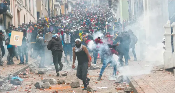  ??  ?? Manifestan­tes chocan con fuerzas de seguridad en protesta por las medidas económicas aprobadas por el presidente de Ecuador, Lenín Moreno.