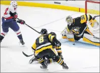  ?? AP PHOTO ?? Washington Capitals’ Evgeny Kuznetsov gets the game-winning shot between the pads of Pittsburgh Penguins goaltender Matt Murray during the overtime period Monday’s NHL playoff game in Pittsburgh.