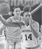  ?? CARLOS OSORIO/AP ?? Michigan guard Akienreh Johnson (14) drives to the basket during the first half Sunday in the Big Ten Conference showdown against rival Ohio State in Ann Arbor, Mich.