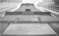  ??  ?? The corner stone of The New York Federal Reserve Bank is seen surrounded by financial institutio­ns in New York’s financial district. Part of the Internatio­nal Monetary Fund’s twiceannua­l review of financial stability, the report follows moves by the US...