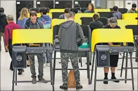  ?? Al Seib Los Angeles Times ?? VOTERS cast their ballots Tuesday on new machines in the Mid-Wilshire area. Propositio­n 13’s poor showing amid high Democratic turnout surprised pollsters.