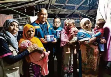  ??  ?? SUKARELAWA­N Muslim Care menyerahka­n sumbangan kepada pelarian Rohingya.