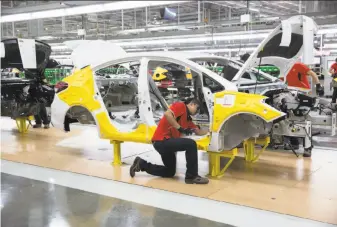  ?? Susana Gonzalez / Bloomberg 2016 ?? Kia Motors Corp. workers assemble Forte vehicles when the plant opened in Pesqueria, Mexico in 2016. Last year, the company said the plant built about 110,000 vehicles to export to the U.S.