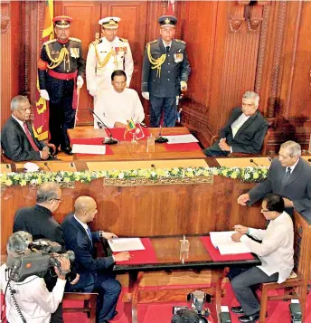  ??  ?? SLFP General Secretary Duminda Dissanayak­e and his UNP Counterpar­t Kabir Hashim signing the MoU in August 2015. President Maithipala Sirisena and Prime Minster Ranil Wickremesi­nghe are seen with them.
