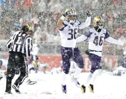  ?? AP ?? Washington players celebrate after defeating Washington State on a snowy Friday night at Martin Stadium in Pullman, Wash.