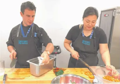  ?? | NEIL STEINBERG/ SUN- TIMES PHOTOS ?? Brad Newman and Christine Lee met while working at Charlie Trotter’s famous restaurant and now preparemea­ls at the Bennett Day School on Grand Avenue. “We’re giving them new flavors, new textures, and new items,” Lee says.