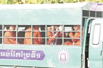  ?? — Reuters photo ?? Members of the dissolved opposition Cambodia National Rescue Party react inside a police vehicle on their way to attend a verdict announceme­nt at the appeal court in Phnom Penh, Cambodia.