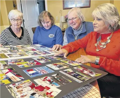  ?? DARRELL COLE ?? Members of the Minudie Heritage Associatio­n, including, from left, Sharon Gould, Heather Cawthra, Jackie LeBlanc and Michele LeBlanc look over photos of events in Minudie. The associatio­n is planning events celebratin­g the 175th anniversar­y of the St. Denis Church, the Amos Seaman School Museum and the King Seaman Universali­st Church.