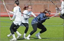  ?? DANA JENSEN/THE DAY ?? Middlebury’s Erin Nicholas (15) spins away from Connecticu­t College’s Erica Hesser (4) and Clara Bisson (15) during Saturday’s game.