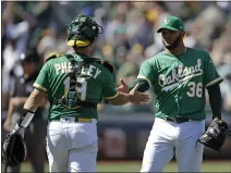  ?? BEN MARGOT – THE ASSOCIATED PRESS ?? Yusmeiro Petit, right, shakes catcher Josh Phegley’s hand after pitching a perfect ninth inning to nail down the A’s 8-4victory over the Astros.