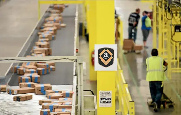  ?? NOAH BERGER ?? Outgoing shipments flow along a conveyor belt at an Amazon Fulfillmen­t Center on Cyber Monday in Tracy, California, in November.