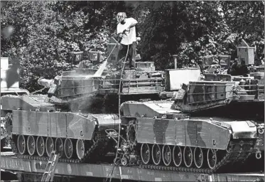  ?? JOSE LUIS MAGANA/AP ?? A worker pressure washes an Abrams tank in a rail yard Tuesday in Washington ahead of a Fourth of July celebratio­n.