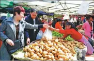  ?? YU FANGPING / FOR CHINA DAILY ?? Consumers buy vegetables at a market in Qingdao, Shandong province.