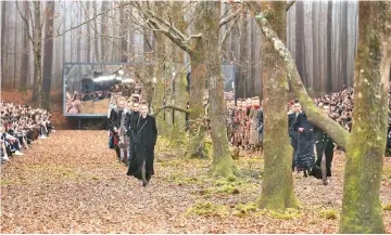  ?? — WP-Bloomberg photo ?? Models stroll through the finale of the Chanel autumn-winter 2018 show, in a woodland set.