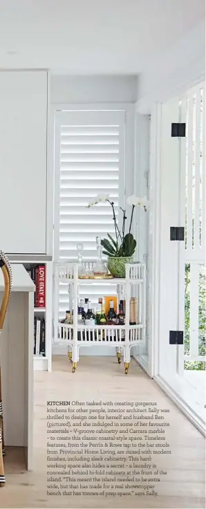  ??  ?? KITCHEN Often tasked with creating gorgeous kitchens for other people, interior architect Sally was thrilled to design one for herself and husband Ben (pictured), and she indulged in some of her favourite materials – V-groove cabinetry and Carrara marble – to create this classic coastal-style space. Timeless features, from the Perrin &amp; Rowe tap to the bar stools from Provincial Home Living, are mixed with modern finishes, including sleek cabinetry. This hardworkin­g space also hides a secret – a laundry is concealed behind bi-fold cabinets at the front of the island. “This meant the island needed to be extra wide, but that has made for a real showstoppe­r bench that has tonnes of prep space,” says Sally.