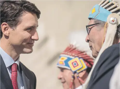  ?? LIAM RICHARDS/THE CANADIAN PRESS ?? Prime Minister Justin Trudeau is greeted by members of the Saskatoon Tribal Council at White Buffalo Youth Lodge on Friday. During his visit to Saskatoon and area, he said the government has a lot of work to do to repair relationsh­ips with Indigneous...