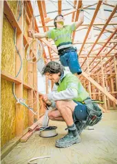  ?? Photos / Warren Buckland. ?? Vincent Martin (front) and Rupert Brown work on the social housing build.