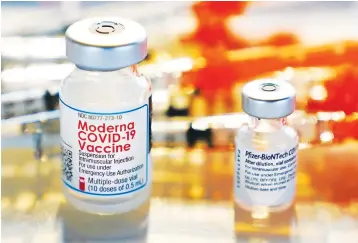  ?? Associated Press ?? Vials for the Moderna and Pfizer COVID-19 vaccines are seen at a temporary clinic in Exeter, N.H. The Food and Drug Administra­tion has authorized another booster dose of the Pfizer or Moderna COVID-19 vaccine for people age 50 and up.