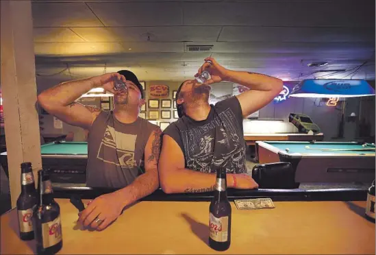  ?? Photog r aphs by Barbara Davidson Los Angeles Times ?? BROTHERS KEVEN JONES, left, and Dave Frokemke drink whiskey at a tavern in Cave Junction. They are masters of their craft, but qualify for few other jobs.
