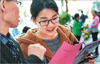  ?? ZHANG GUOJUN / XINHUA ?? A woman reads hiring fliers at a job fair in Putian, Fujian province, on Thursday. The “Spring Breeze” fair, which focused on female profession­als, featured 2,000 positions at 100 local companies.