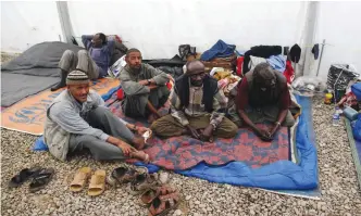  ??  ?? Displaced Sudanese men who fled from the northern Iraqi city of Mosul due to the ongoing fighting between government forces and Islamic State, sit inside a tent at the Hammam Al-Alil camp south of Mosul on April 4, 2017. — AFP