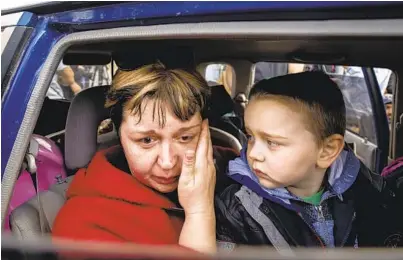  ?? EVGENIY MALOLETKA AP ?? Natalia Pototska and her grandson Matviy arrive at a center for displaced people in Zaporizhzh­ia, Ukraine, on Monday.