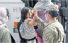  ??  ?? An evacuated Afghan girl gets a high five from US soldier Kimberly Hernandez at Washington Dulles Airport.