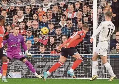  ?? AFP PIC ?? Manchester United's Rasmus Hojlund (right) scores their second goal with his chest during the Premier League match against Luton at Kenilworth Road in London on Sunday.