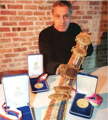  ?? SUN-TIMES FILE PHOTOS ?? George Randazzo in 1998 showing off a Rocky Marciano championsh­ip belt and three of Matt Biondi’s Olympic gold medals.