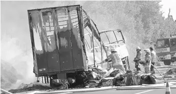  ??  ?? Firefighte­rs work at the site where a coach burst into flames after colliding with a lorry on a motorway near Muenchberg in this still image taken from video. — Reuters photo